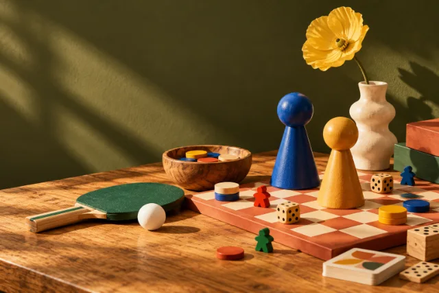 Spillebrikker, terninger og et bordtennisbat på et bord